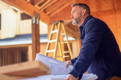 contractor with plans at a worksite